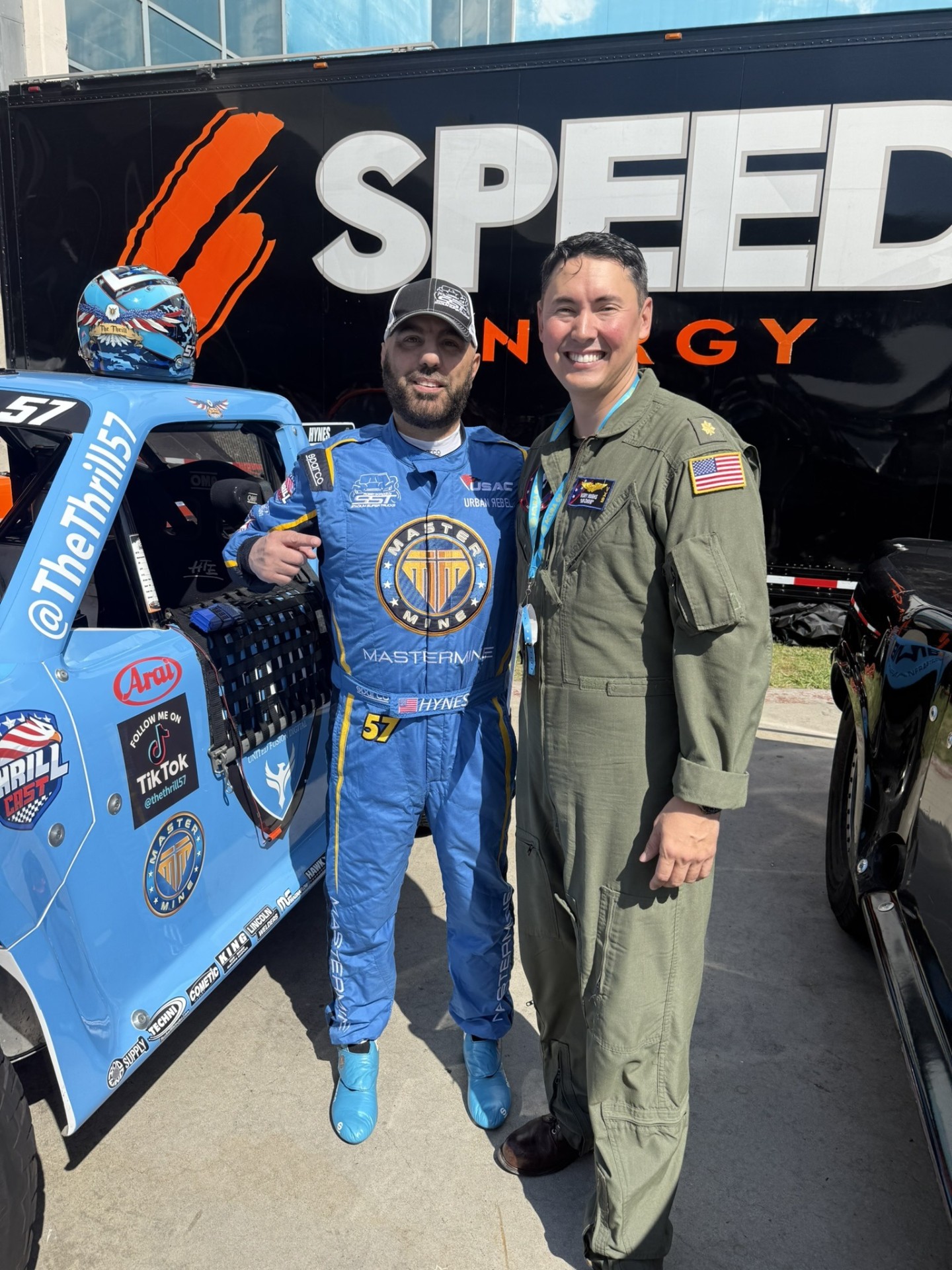 Bill Hynes with U.S. Navy F/A-18 pilot Mr. Chow beside the Team UFD Racing #57 Stadium SUPER Truck at Long Beach